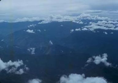 [Aerial view of a mountainous area under clouds in Papua New Guinea]
