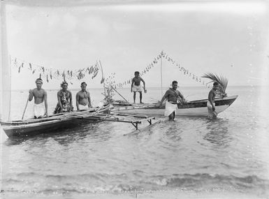 [Group of Polynesian men with canoes in the water]