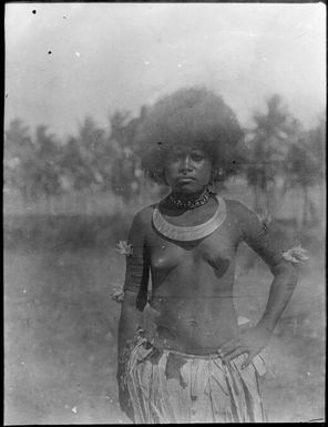 Woman wearing a grass skirt with her hand on her hip, Papua, ca. 1923 / Sarah Chinnery