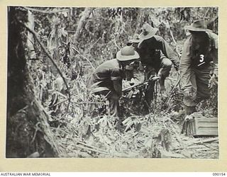 DAGUA, NEW GUINEA. 1945-03-27. PRIVATE J.E. CRIMMINS (3), ACCOMPANIES 2/2 INFANTRY BATTALION STRETCHER BEARERS FROM A FORWARD PATROL BACK TO A COMPANY HEADQUARTERS. THE PHOTOGRAPH INDICATES THE ..