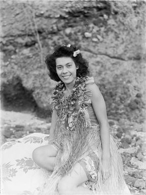 [Half-length portrait of a pacific island woman sitting on a patterned blanket]