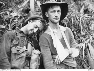 1943-08-03. NEW GUINEA. PTE. A. KEAN OF SWAN HILL, VIC., DOZES DURING A HALT NEAR MUBO. WITH HIM IS PTE. FRANK SOUTTER, OF CLIFTON HILL, VIC. WHO WAS SHOT THROUGH THE ARM DURING FIGHTING IN THE ..