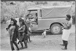 People on a road, next to a truck