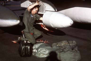A maintenance crewman unloads fly-away kits from the luggage pod of an F-4 Phantom II aircraft from the 34th Tactical Fighter Squadron during a rest stop at the base. The redeployment of F-4 aircraft from Korat Air Base, Thailand, to the United States because of a reduction in forces is known as Coronet Slice and began on July 22, 1975