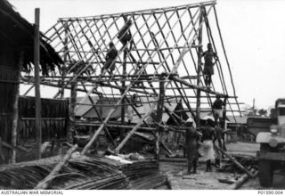 TADJI AIRSTRIP, AITAPE, NEW GUINEA. 1944. NATIVES CONSTRUCT A LARGE HUT FOR THE PADRE WITH NO. 100 SQUADRON RAAF, USING LOCAL MATERIALS