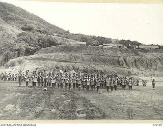 NADZAB, NEW GUINEA. 1944-09-26. MEMBERS OF B COMPANY, 1ST NEW GUINEA INFANTRY BATTALION AWAITING INSPECTION BY VX13 LIEUTENANT-GENERAL S.G. SAVIGE, CB, CBE, DSO, MC, ED, GOC NEW GUINEA FORCE AT ..