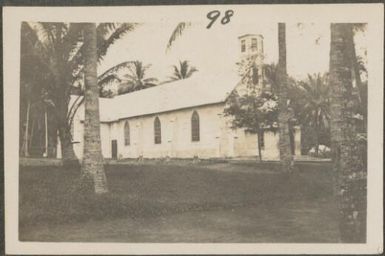 Stone mission church with palm trees, New Britain Island, Papua New Guinea, probably 1916