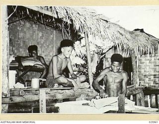 PORT MORESBY, PAPUA. 1942-07. JAPANESE BOMBING RAIDS OVER PORT MORESBY CAUSED MOST OF THE NATIVE POPULATION TO GO TO THE HILLS. A SMALL NUMBER OF NATIVE "BOYS" REMAINED, OTHERS WERE BROUGHT BACK ..