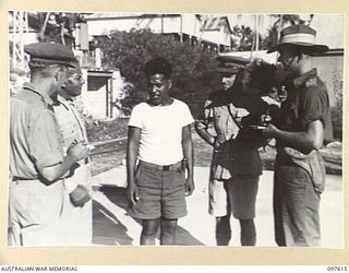 OCEAN ISLAND, 1945-10-01. WAR CORRESPONDENTS INTERVIEWING GILBERTESE ISLANDER NABETARI WHO LIVED AT SEA FOR 7 MONTHS IN ESCAPING FROM THE JAPANESE DURING THE OCCUPATION. MAJ R.F. WAKEFIELD, BRITISH ..
