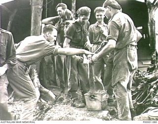 THE SOLOMON ISLANDS, 1945-03-27. AUSTRALIAN ARMY PATROL BREAKING FOR A CUP OF TEA AT A CAMP SITE ON THE NUMA NUMA TRAIL ON BOUGAINVILLE ISLAND. (RNZAF OFFICIAL PHOTOGRAPH.)