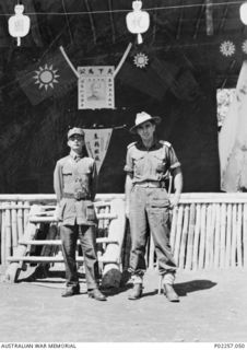Portrait of an unidentified Australian Army lieutenant (right) with a Lieutenant Colonel Woo Yien, commander of the Nationalist Chinese Army in New Britain, at a Japanese prisoner-of-war (POW) ..