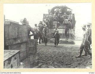 SARANG HARBOUR, NEW GUINEA. 1944-05-31. TROOPS AND STORES OF THE 37/52ND INFANTRY BATTALION UNLOADING FROM AN AMERICAN LANDING BARGE. THE AREA WAS USED AS A FORWARD BASE DURING PREPARATIONS FOR THE ..