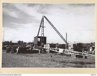 LAE, NEW GUINEA, 1945-11-26. THE GUINEA AIRWAYS "STIFF-LEG" CRANE. IT IS NO LONGER USED BUT WAS STILL SERVICEABLE WHEN AUSTRALIAN AND AMERICAN FORCES ENTERED LAE. THE AREA IS NOW OCCUPIED BY 33 ..