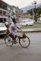 French Polynesia, woman and girl riding bicycle through town