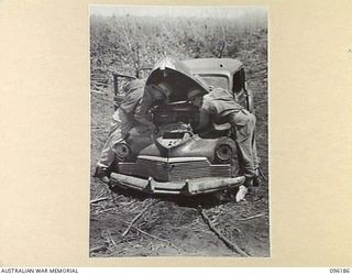 CAPE PUS, WEWAK AREA, NEW GUINEA, 1945-09-07. PRIVATE J.N. WICKS (1), AND PRIVATE S.R. WILLIAMS (2), MEMBERS OF 2/2 INFANTRY BATTALION, SEARCHING AND SCROUNGING UNDER THE BONNET OF A JAPANESE STAFF ..