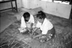 Enui teaching Luta to make takapau 'coconut frond floor mat' at Adult Learning Centre.