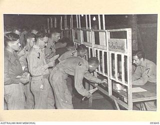 PALMALMAL PLANTATION, JACQUINOT BAY, NEW BRITAIN, 1945-07-03. TROOPS QUEUE AT THE NINE TOTE WINDOWS TO PLACE BETS BEFORE THE FIRST RACE MEETING OF THE NEW BRITAIN TURF CLUB AT 18 ADVANCED ORDNANCE ..