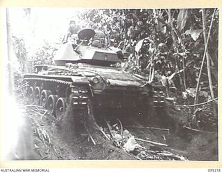 TOROKINA AREA, BOUGAINVILLE, 1945-08-14. AN M24 LIGHT TANK TOPPING THE CREST AFTER A CLIMB UPHILL IN MUD AND JUNGLE CONDITIONS DURING TESTS OF THE VEHICLE CARRIED OUT BY THE BRITISH WAR OFFICE ..