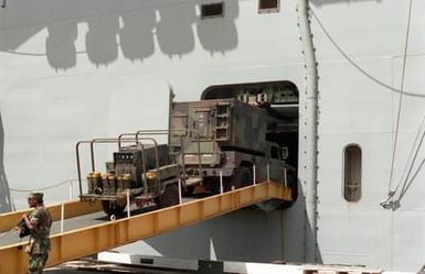 An M998 High-Mobility Multipurpose Wheeled Vehicle (HMMWV), with shelter attached and pulling a generator, is driven aboard the amphibious assault ship USS BELLEAU WOOD (LHA-3). The vessel is transporting equipment of the 25th Infantry Division to the island of Kauai as part of Task Force Garden Isle, a joint military disaster relief effort being conducted in the aftermath of Hurricane Iniki