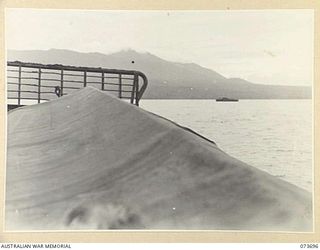 AT SEA, NEW GUINEA. 1944-06-01. AMERICAN LANDING BARGES CARRYING MEMBERS OF THE 37/52ND INFANTRY BATTALION OBTAINS SUPPORT FROM A MOTOR LAUNCH IN BACKGROUND DURING THE FINAL APPROACH TO THE LANDING ..