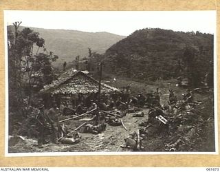 PALANKO, NEW GUINEA. 1943-12. TROOPS OF THE 26TH AUSTRALIAN INFANTRY BRIGADE RELAXING ON ARRIVAL AT THE CAMP. IDENTIFIED PERSONNEL ARE: PRIVATE GIBSON (1); NX65970 SIGNALMAN A. ANDERSON (3); ..