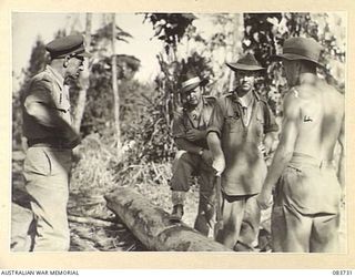 AITAPE, NEW GUINEA. 1944-11-23. MAJOR- GENERAL J E S STEVENS, COMMANDER 6 DIVISION, (1), CHATTING INFORMALLY WITH 2/8 FIELD COMPANY, ROYAL AUSTRALIAN ENGINEERS TROOPS ENGAGED IN CUTTING TIMBER FOR ..