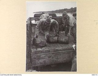 MUSCHU ISLAND, NEW GUINEA. 1945-09-11. JAPANESE SOLDIERS UNLOADING THE FIRST OF RATIONS SUPPLIED BY HEADQUARTERS 6 DIVISION TO JAPANESE PERSONNEL ON MUSCHU AND KAIRIRU ISLANDS. THE RATIONS ..