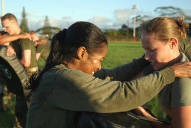 Two female US Marine Corps (USMC) Marines, Headquarters and Service Battalion (H&S BN), Marine Forces Pacific (MARFORPAC), Camp H. M. Smith, Hawaii (HI), participate in a unit wide conditioning exercise to enhance their combat readiness and improve their personal physical fitness
