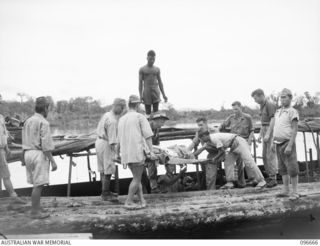 BONIS PENINSULA, BOUGAINVILLE. 1945-09-16. MEDICAL PERSONNEL OF 17 FIELD AMBULANCE SUPERVISING THE LOADING OF SERIOUSLY ILL JAPANESE TROOPS ON TO AN AMBULANCE BARGE FOR MOVEMENT TO 17 FIELD ..