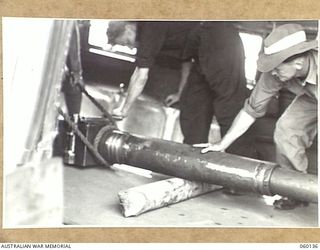 WARD'S DROME, NEW GUINEA. 1943-11-16. TROOPS OF THE 2/5TH AUSTRALIAN FIELD REGIMENT, 7TH AUSTRALIAN DIVISION, LOADING THE BARREL OF A LONG 25-POUNDER GUN INTO A DOUGLAS TRANSPORT AIRCRAFT, DURING ..