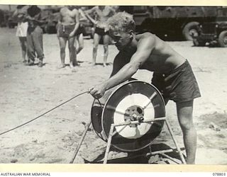 TOROKINA, BOUGAINVILLE ISLAND. 1945-01-28. A REELMAN PLAYING OUT THE LINE DURING AN EXAMINATION OF AUSTRALIAN ARMY PERSONNEL FOR THEIR BRONZE LIFE SAVING MEDALLION