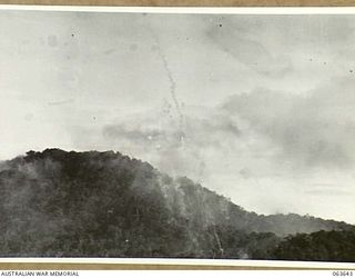 FARIA RIVER, NEW GUINEA. 1944-01-20. SMOKE RISING FROM JAPANESE POSITIONS ACROSS MAIN CREEK, AFTER A STRIKE BY ALLIED MITCHELL BOMBERS