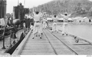 PHYSICAL DRILL ON THE WHARF AT PORT MORESBY. THE TROOPS WERE KEPT FIT BY PLENTY OF THIS SORT OF THING DURING THE COOLER HOURS OF THE DAY. (DONOR LIEUTENANT COMMANDER G.A. HILL, RNR.)