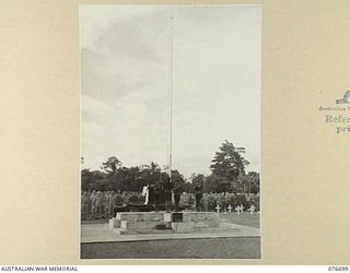 LAE, NEW GUINEA. 1944-11-05. BUGLERS OF THE ROYAL PAPUAN CONSTABULARY SOUND "REVEILLE" AS THE FLAG IS HOISTED TO FULL MAST AT THE CONCLUSION OF A SOLEMN REQUIEM MASS AT THE LAE WAR CEMETERY