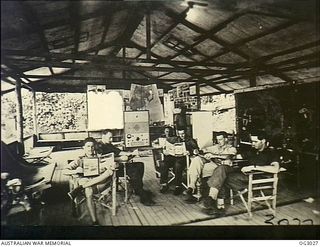 TOROKINA, BOUGAINVILLE ISLAND, SOLOMON ISLANDS. 1945-07-07. PILOTS OF NO. 5 (TACTICAL RECONNAISSANCE) SQUADRON RAAF ENJOY A BRIEF REST BETWEEN SORTIES READING IN THEIR CREW-ROOM AT TOROKINA. LEFT ..