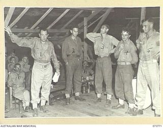 LAE, NEW GUINEA. 1944-06-08. PERSONNEL OF THE 2/7TH ADVANCED WORKSHOP ON STAGE DURING AN EDUCATIONAL QUIZ AT THEIR CONCERT. THE CONCERT WAS HELD ON THE FIRST ANNIVERSARY OF THE UNIT'S FORMATION. ..