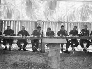 SIAR, NEW GUINEA. 1944-06-20. OFFICERS OF THE 58/59TH INFANTRY BATTALION EATING LUNCH IN THE OFFICER'S MESS. IDENTIFIED PERSONNEL ARE:- VX7562 MAJOR H.G. SWEET (1); VX186 LIEUTENANT COLONEL G. R. ..