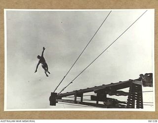 PORT MORESBY, NEW GUINEA. 1943-11-28. COMPETITOR IN THE HIGH DIVING EVENT, EXECUTES A SWALLOW DIVE AT THE ALLIED SERVICES GRAND SWIMMING CARNIVAL