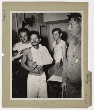 Photograph of Japanese Prisoner of War with Coast Guardsmen Aboard Assault Transport
