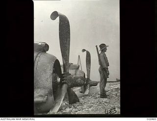 KIRIWINA, TROBRIAND ISLANDS, PAPUA. C. 1944-02-04. LEADING AIRCRAFTMAN R. H. PROCTOR OF GUFFLE, NSW, STANDS GUARD OVER A CRASH-LANDED BEAUFIGHTER AIRCRAFT OF NO. 30 SQUADRON RAAF. NOTE THE ..