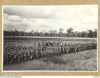 WONDECLA, QLD. 1944-04-15. MEMBERS OF THE HEADQUARTERS COMPANY, 2/1ST INFANTRY BATTALION GIVE "EYES RIGHT" AS THEY MARCH PAST THEIR COMMANDING OFFICER, NX163 LIEUTENANT COLONEL P.A. CULLEN, DSO. ..