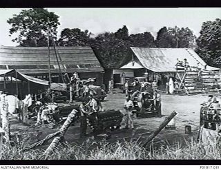 Goodenough Island, D'Entrecasteaux Islands, Papua, 1944-04-11. Members of No. 26 Repair and Salvage Unit RAAF at work in the foreground on various aircraft engines. In the midground at left is a ..