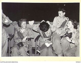 LAE AREA, NEW GUINEA, 1945-08-22. THE MASKED MYSTERY BALL HELD AT NO. 3 SERGEANTS' MESS, HEADQUARTERS FIRST ARMY SHOWING AUSTRALIAN WOMEN'S ARMY SERVICE UNMASKING