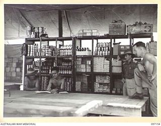 RABAUL, NEW BRITAIN. 1945-09-26. THE DISPLAY ARRANGEMENT AT THE AUSTRALIAN ARMY CANTEENS SERVICE ISSUING POINT IN THE RUINS OF THE BURNS PHILP STORE HOUSE