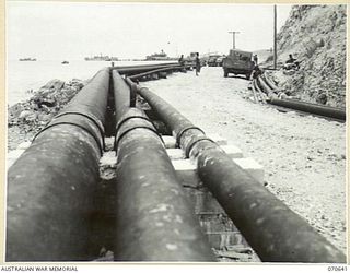 PORT MORESBY, PAPUA, 1944-02-26. MAIN CARGO LINES RUNNING ALONG THE WHARF AT THE BULK OIL INSTALLATIONS OF THE 1ST PETROLEUM STORAGE COMPANY TO THE TANKER