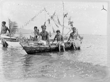 [Group of five Polynesian males with canoes in the water]