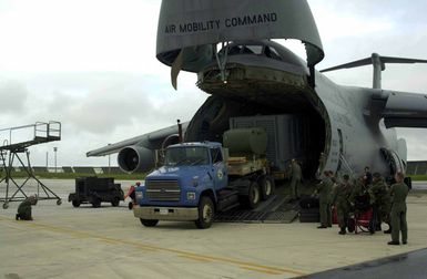 At Andersen Air Force Base (AFB), Guam, Mister Albert Villagomez, a driver with the Defense Commissary Agency (DCA), drives a cargo truck down the cargo ramp of a C-5 Galaxy from Travis Air Force Base (AFB), California