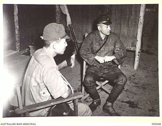 TOKO, BOUGAINVILLE. 1945-08-18. MAJOR OTSU (1) AND SUPERIOR PRIVATE TAKESHITA (2), THE JAPANESE SURRENDER ENVOY PARTY, WAITING IN THE ANTE-ROOM AT HEADQUARTERS 3 DIVISION. THE JAPANESE PARTY WAS ..