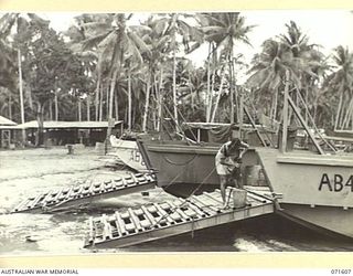 LABU POINT, LAE, NEW GUINEA. 1944-03-24. NX90145 CRAFTSMAN W. HEAD, 1ST WATERCRAFT WORKSHOP, DOING HIS WASHING ON A LANDING BARGE AWAITING REPAIRS
