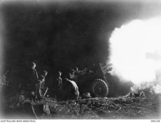 DAGUA, NEW GUINEA. 1945-03-30. A 25-POUNDER IN ACTION AT NIGHT MANNED BY F TROOP, 52 BATTERY 2/2 FIELD REGIMENT PERSONNEL. IDENTIFIED PERSONNEL ARE:- BOMBARDIER M. YOUNG (1); BOMBARDIER R. CUMMINS ..